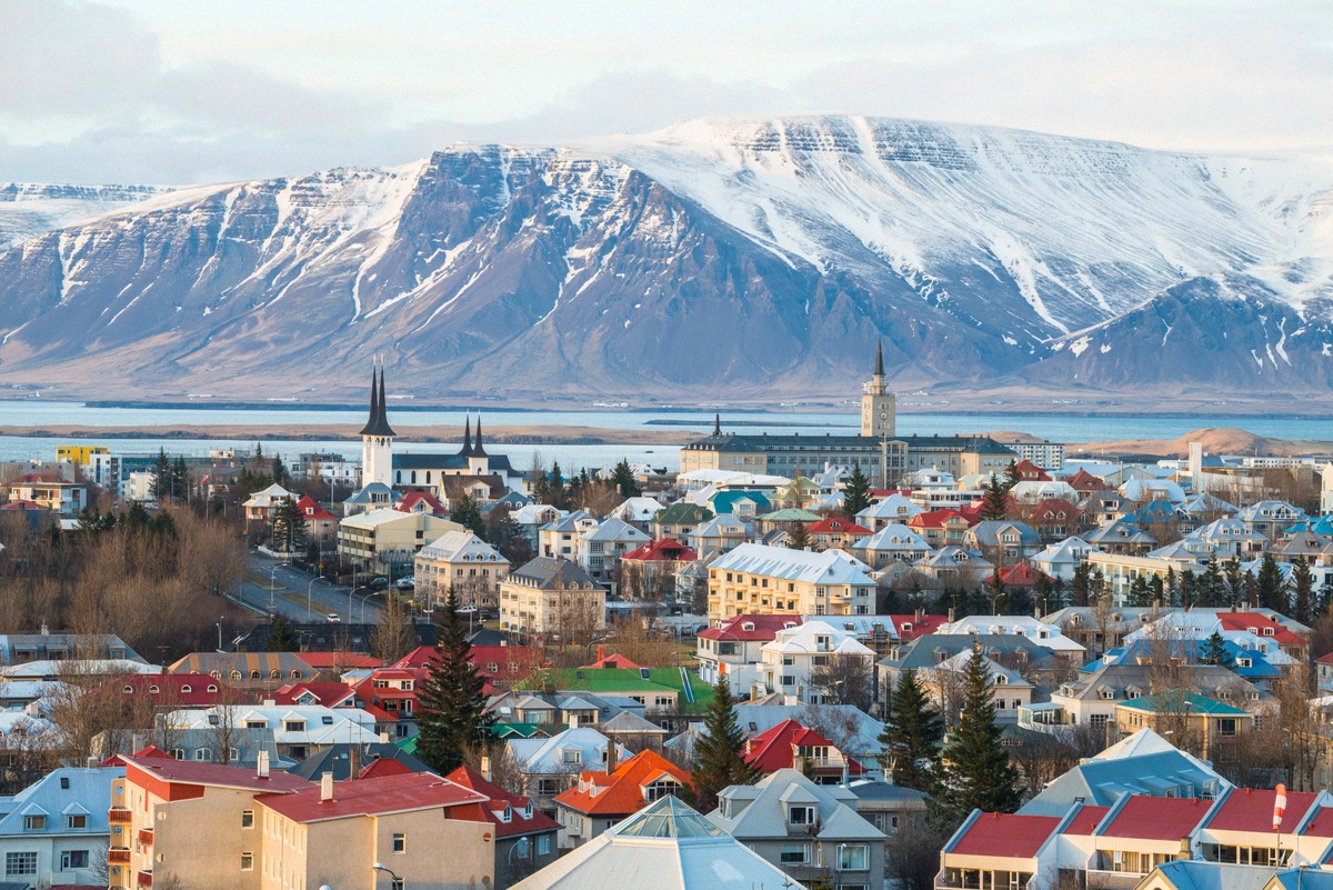 Blick über die Dächer Reykjavíks auf den schneebedeckten Berg Esja